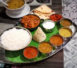 A plate of rice, curry, and assorted dishes is served at a delicious South-Indian restaurant.